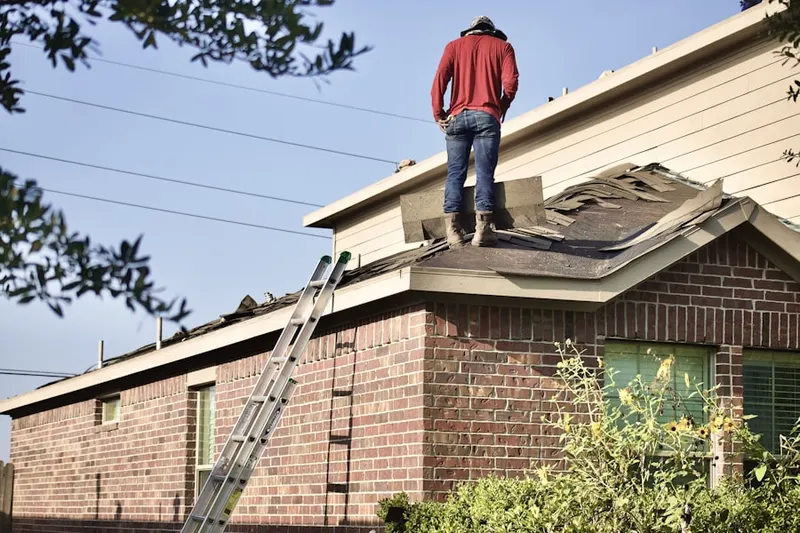 Professional roofer working on a residential roof in Readville